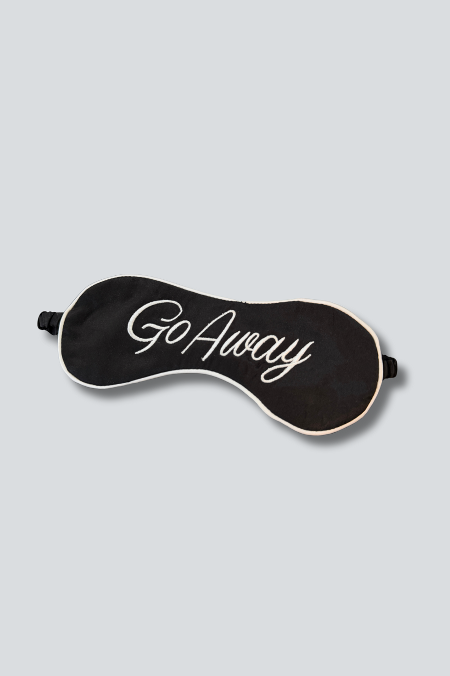 Black sleep mask with 'Go Away' text on a light gray background Main image